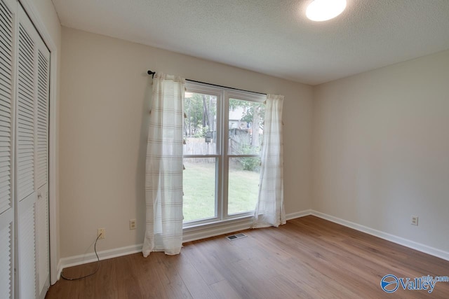 15011 Glory Dr SE, Huntsville, AL 35803 - spare room with baseboards, a healthy amount of sunlight, wood finished floors, and a textured ceiling