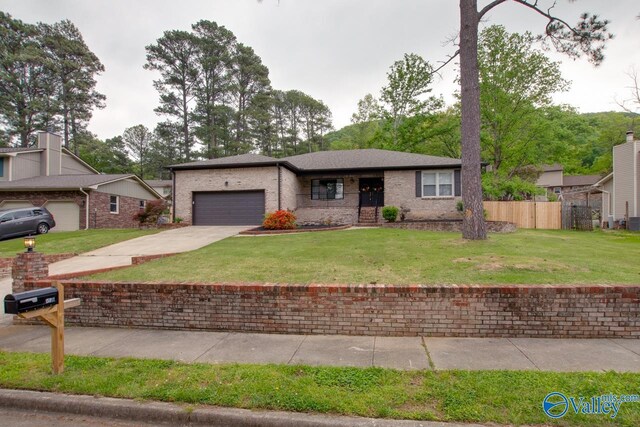 15011 Glory Dr SE, Huntsville, AL 35803 - ranch-style home featuring a front lawn, driveway, an attached garage, fence, and brick siding