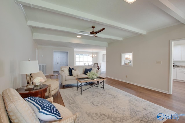 living room with light wood finished floors, beamed ceiling, visible vents, and baseboards