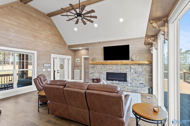 living room with wood-type flooring, wood walls, ceiling fan, and beam ceiling