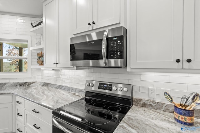 kitchen with light stone countertops, stainless steel appliances, white cabinetry, and tasteful backsplash