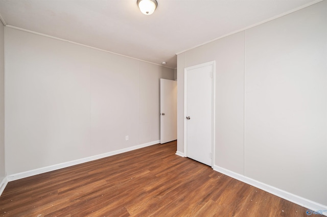 unfurnished room with wood finished floors, baseboards, and ornamental molding