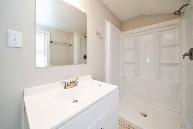 full bath with vanity, a shower stall, and vaulted ceiling