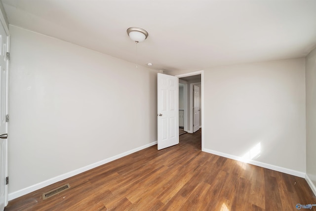 spare room featuring visible vents, baseboards, and wood finished floors