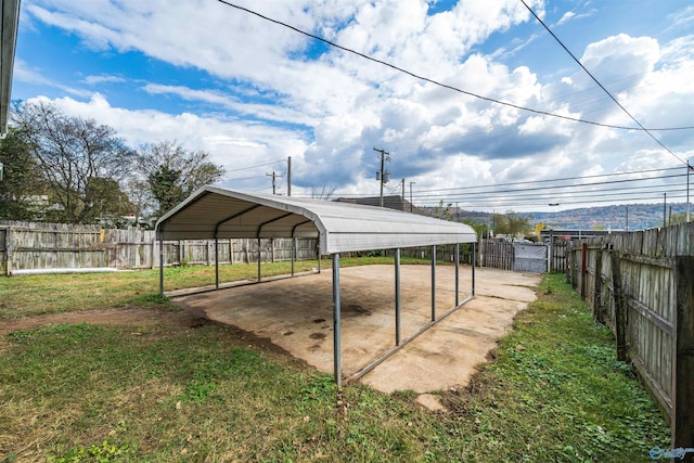 view of yard with a detached carport, a gate, and a fenced backyard