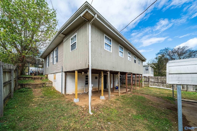 rear view of house with a fenced backyard and a lawn
