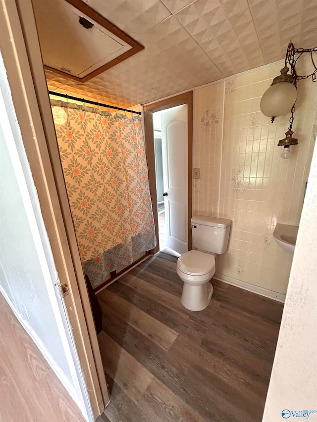 bathroom with walk in shower, hardwood / wood-style floors, and toilet