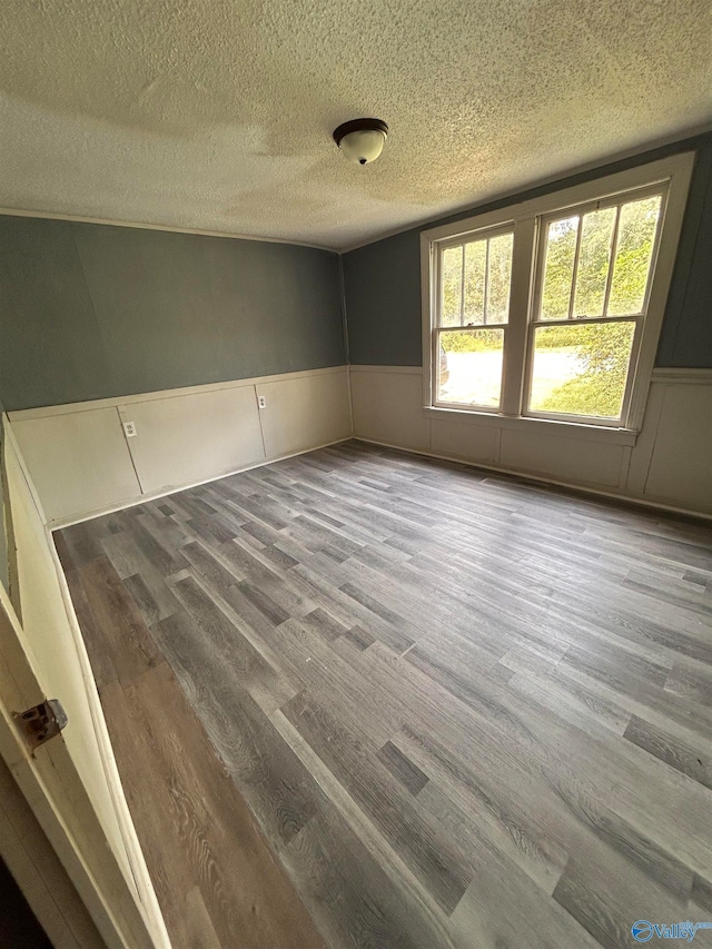 spare room with hardwood / wood-style flooring and a textured ceiling