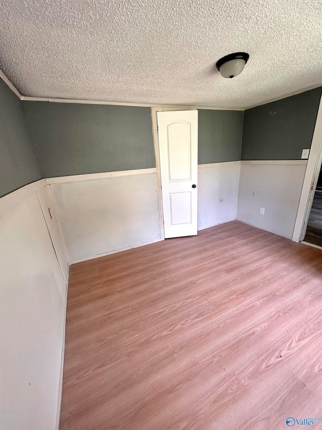 unfurnished bedroom featuring a textured ceiling and light hardwood / wood-style floors