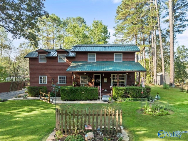 view of front of property with a shed, a front yard, and a porch