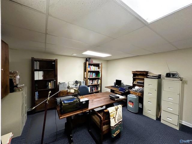 office area with a paneled ceiling and dark carpet