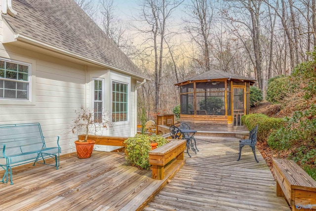 deck featuring a gazebo and a sunroom