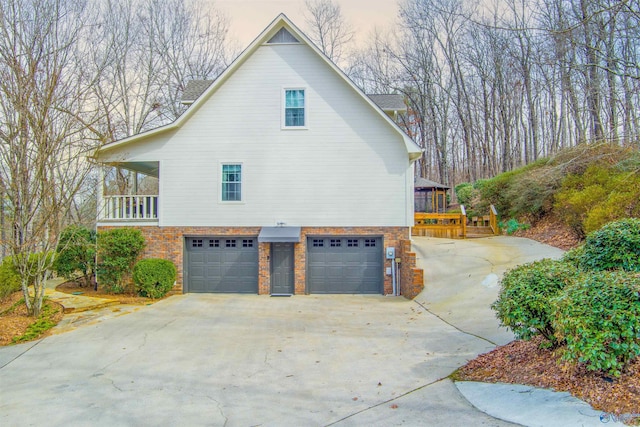 view of property exterior featuring concrete driveway, brick siding, and an attached garage