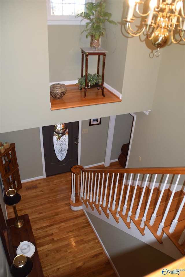 entryway with stairs, wood finished floors, and baseboards