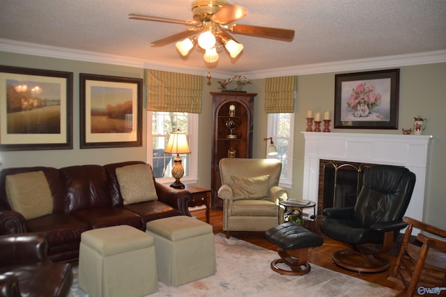 living area with crown molding, a wealth of natural light, a fireplace, and wood finished floors