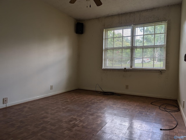 empty room with ceiling fan and parquet flooring