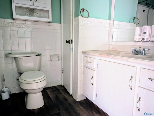 bathroom featuring tile walls, toilet, vanity, and wood-type flooring