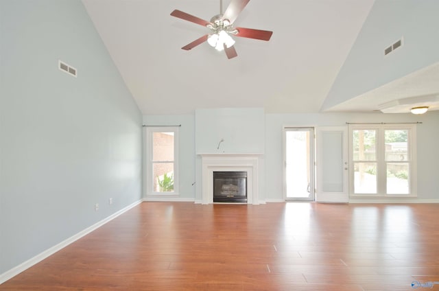 1422 Lake Crest Dr SW, Decatur, AL 35603 - unfurnished living room featuring high vaulted ceiling, a glass covered fireplace, wood finished floors, ceiling fan, and baseboards