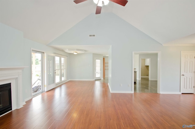 1422 Lake Crest Dr SW, Decatur, AL 35603 - unfurnished living room with ceiling fan, a glass covered fireplace, high vaulted ceiling, wood finished floors, and baseboards