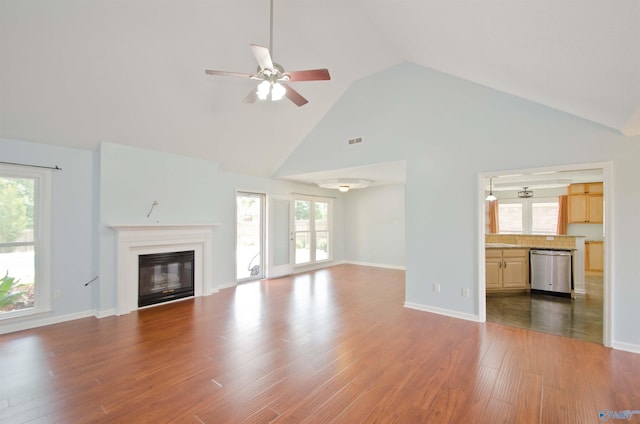 1422 Lake Crest Dr SW, Decatur, AL 35603 - unfurnished living room featuring ceiling fan, high vaulted ceiling, wood finished floors, a glass covered fireplace, and baseboards
