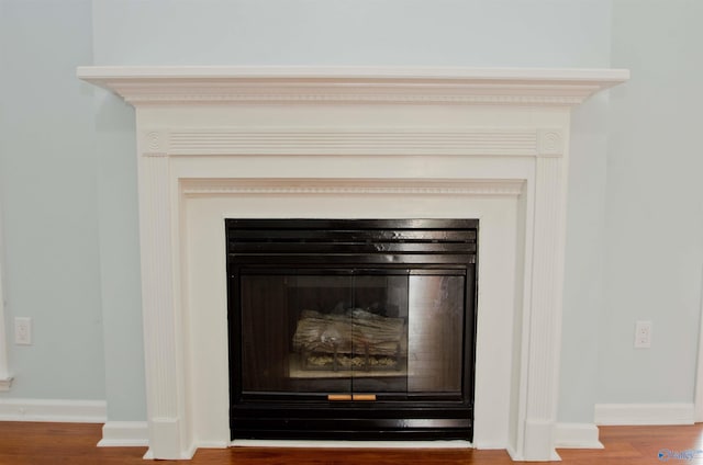 1422 Lake Crest Dr SW, Decatur, AL 35603 - detailed view of a glass covered fireplace, wood finished floors, and baseboards