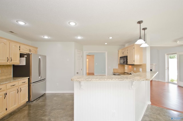 1422 Lake Crest Dr SW, Decatur, AL 35603 - kitchen featuring black microwave, freestanding refrigerator, tasteful backsplash, a breakfast bar, and recessed lighting