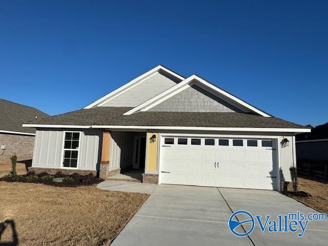 view of front facade with an attached garage, concrete driveway, and roof with shingles