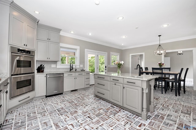 1211 SW Rountree Pl, Madison, AL 35756 - kitchen featuring appliances with stainless steel finishes, a center island with sink, a chandelier, brick patterned floors, and a sink