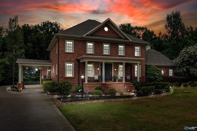 1211 SW Rountree Pl, Madison, AL 35756 - georgian-style home featuring covered porch, driveway, brick siding, a lawn, and an attached carport