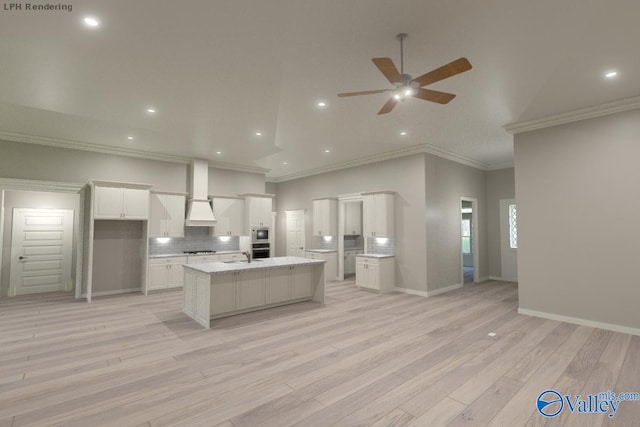 kitchen featuring backsplash, white cabinets, a center island with sink, ceiling fan, and light stone countertops