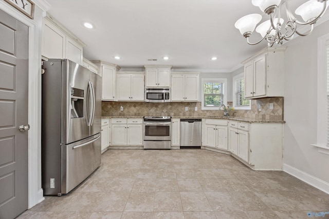 119 Saint Clair Ln, Huntsville, AL 35811 - kitchen featuring appliances with stainless steel finishes, a sink, a chandelier, tasteful backsplash, and white cabinets