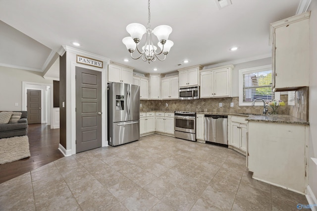 119 Saint Clair Ln, Huntsville, AL 35811 - kitchen with stainless steel appliances, a sink, crown molding, a chandelier, and backsplash