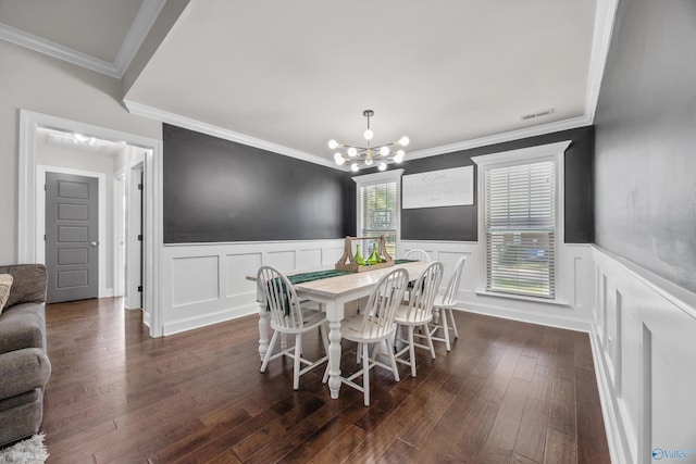 119 Saint Clair Ln, Huntsville, AL 35811 - dining room with a chandelier, a wainscoted wall, dark wood-style flooring, crown molding, and a decorative wall
