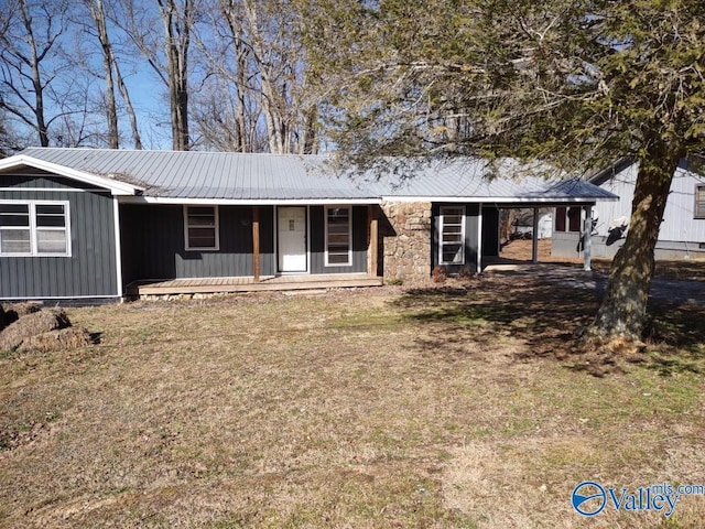 single story home featuring stone siding, a front yard, covered porch, and metal roof