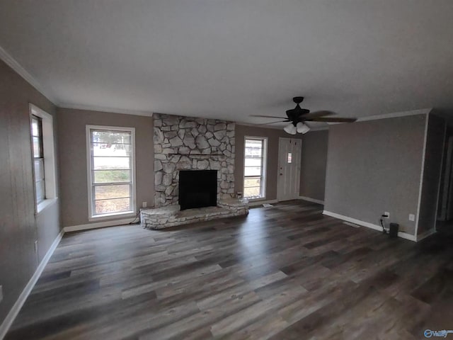 unfurnished living room with a fireplace, wood finished floors, a wealth of natural light, and crown molding