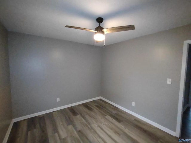 unfurnished room featuring dark wood-style floors, ceiling fan, and baseboards