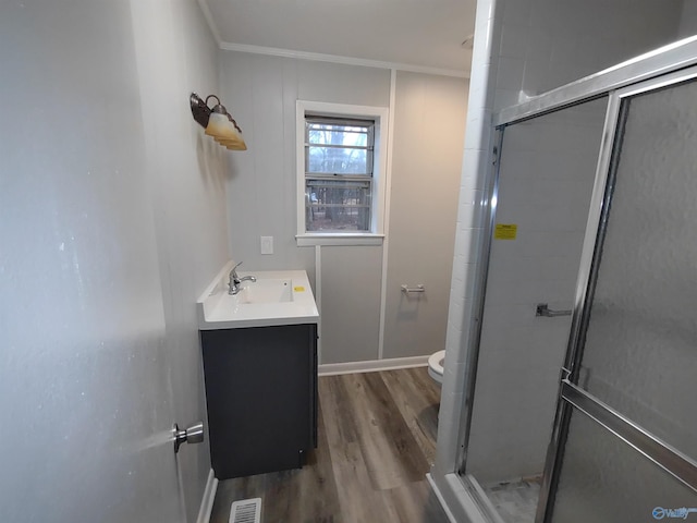 full bathroom with visible vents, toilet, a shower stall, vanity, and wood finished floors