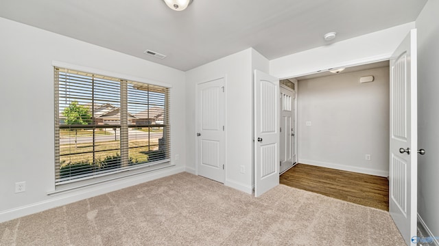 unfurnished bedroom with light carpet and a closet