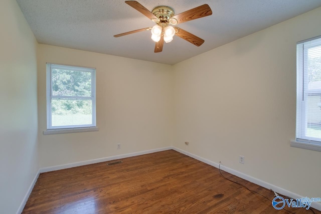 empty room featuring a textured ceiling, dark hardwood / wood-style floors, and ceiling fan