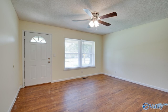 entrance foyer with ceiling fan, hardwood / wood-style flooring, and a textured ceiling