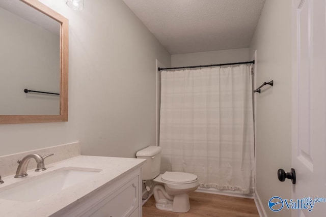 full bath featuring vanity, toilet, a textured ceiling, wood finished floors, and a shower with shower curtain