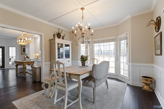 dining area featuring dark wood-type flooring, ornamental molding, and a chandelier