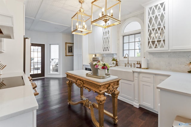 kitchen with hanging light fixtures, sink, a wealth of natural light, and white cabinets