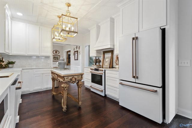 kitchen featuring dark hardwood / wood-style floors, white cabinets, custom exhaust hood, hanging light fixtures, and white appliances