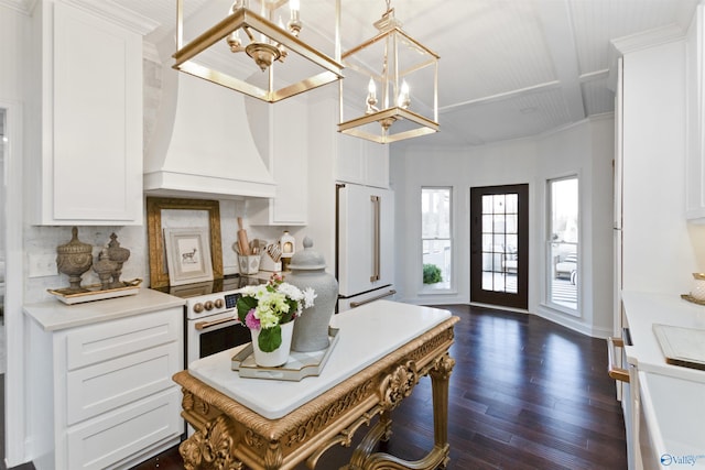 kitchen featuring pendant lighting, white cabinetry, custom exhaust hood, and high end white fridge