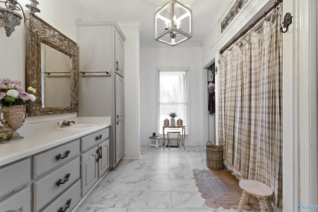 bathroom with crown molding, vanity, and a notable chandelier