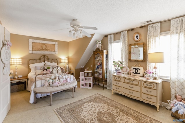 bedroom with ceiling fan, light carpet, and a textured ceiling