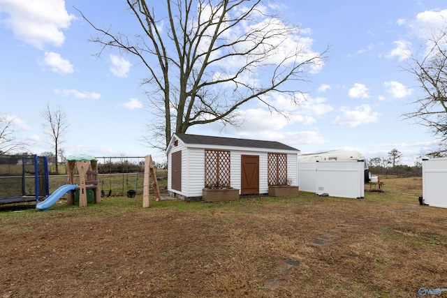 view of outbuilding with a trampoline and a playground