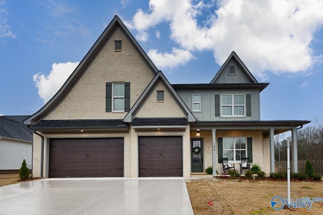 view of front of house featuring brick siding, covered porch, board and batten siding, a garage, and driveway