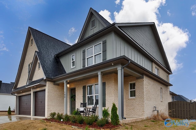 view of home's exterior featuring concrete driveway, a porch, board and batten siding, and brick siding